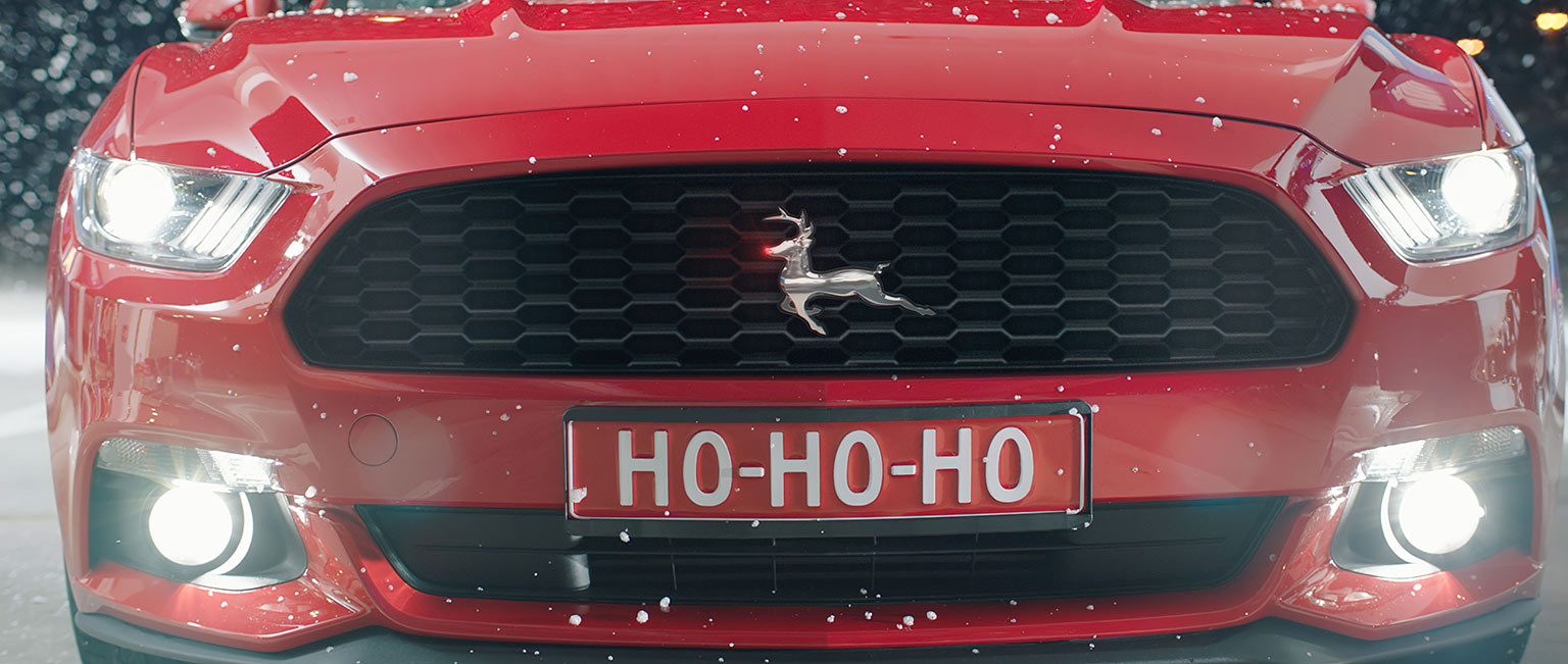 close up of the hood of santa claus' red ford mustang with a reindeer as logo and ho-ho-ho on the license plate