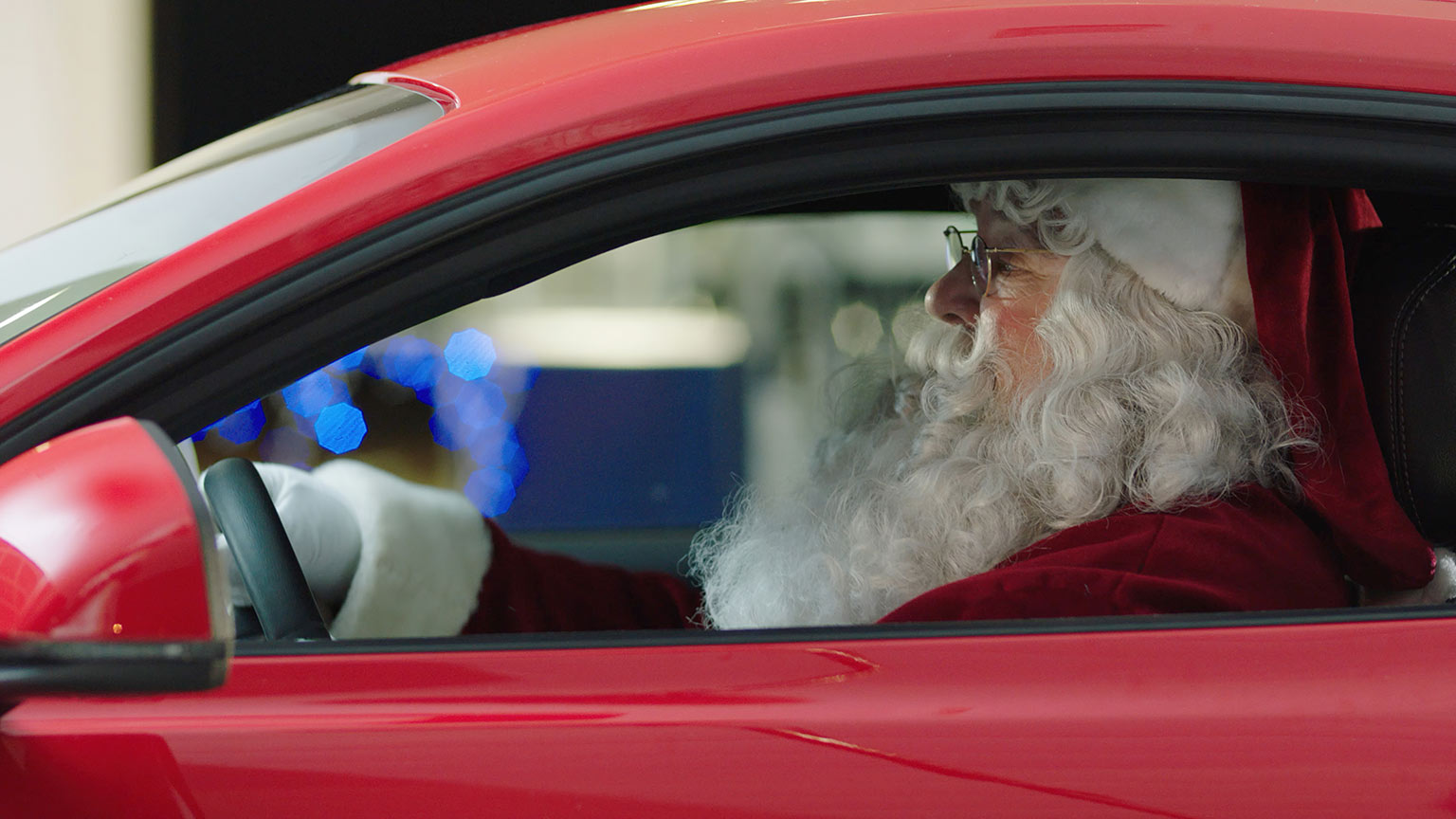 close up of santa claus in his red ford mustang