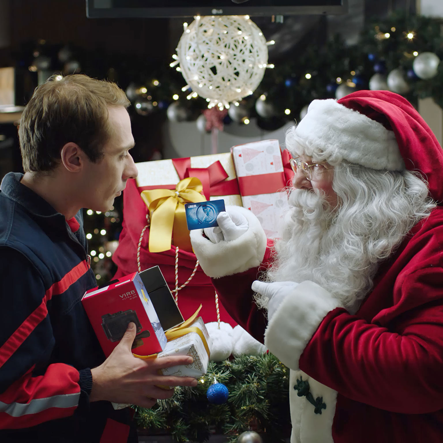 santa claus giving ina presents to gas station employee